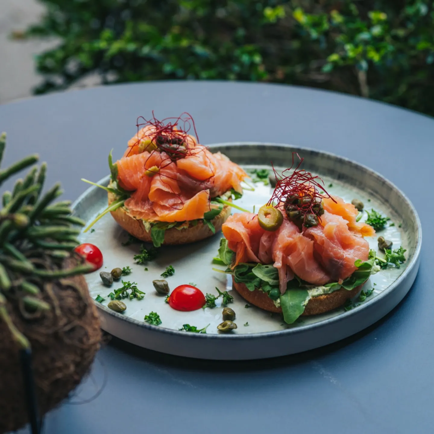 Zwei Bagels mit Räucherlachs, Avocadocreme, Kapern und Rucola im BALŪ Nürnberg