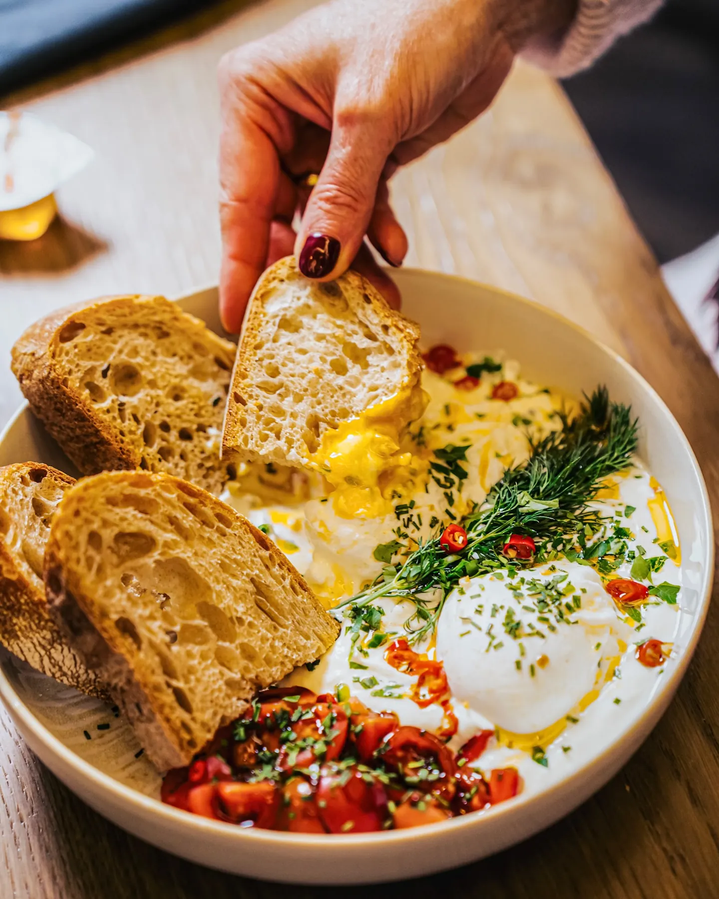 Pochierte Eier auf cremigem Joghurt mit Sauerteigbrot im BALŪ Nürnberg
